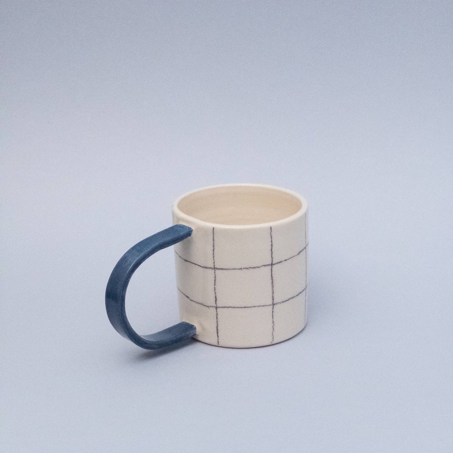 Quadratische Tasse mit blauem Griff