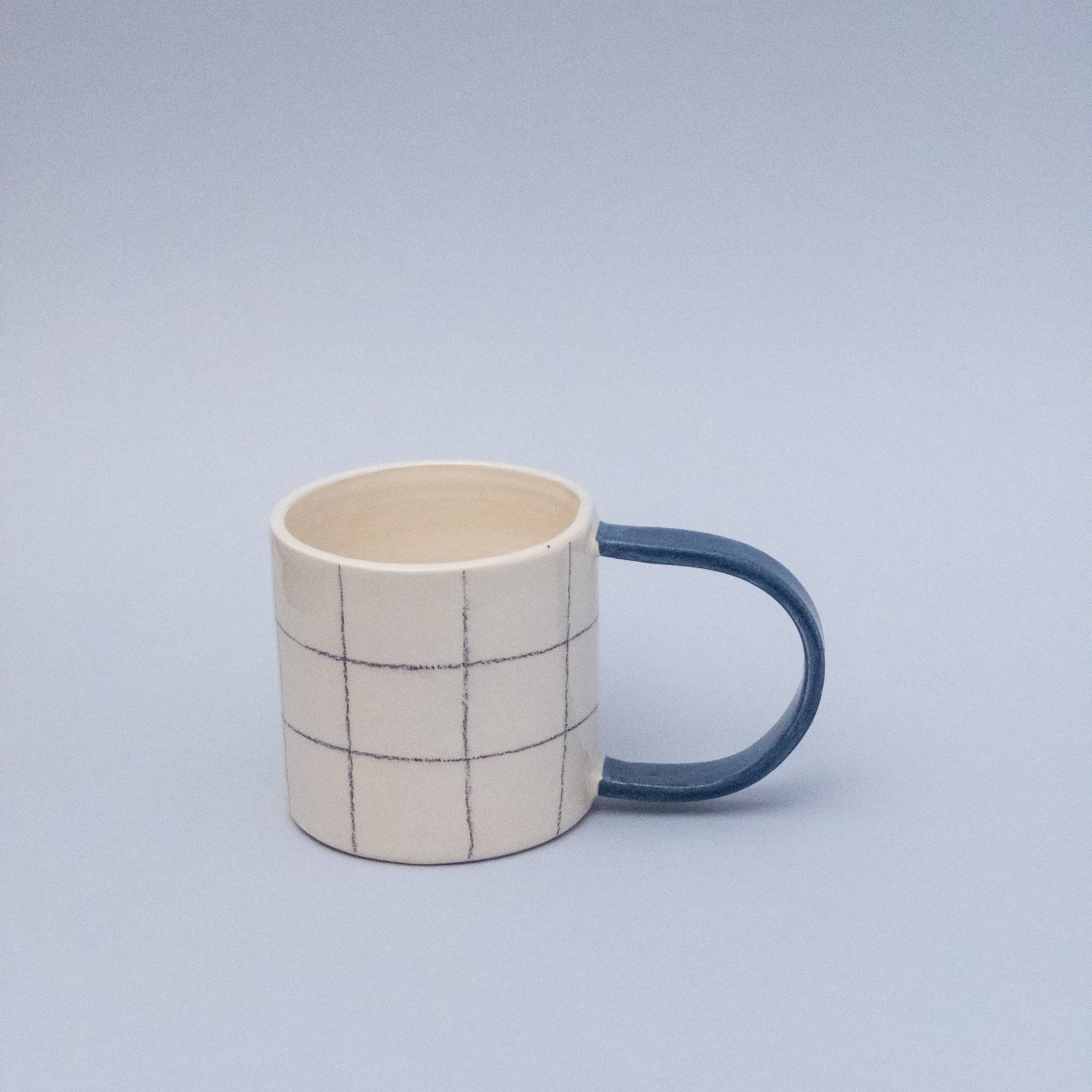 Quadratische Tasse mit blauem Griff