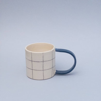 Quadratische Tasse mit blauem Griff