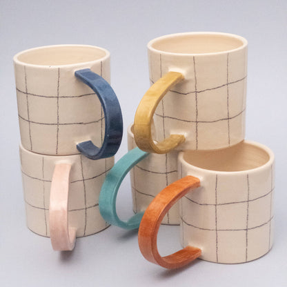 Quadratische Tasse mit blauem Griff